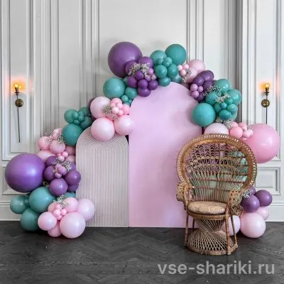 Фотозона с нежно-розовым баннером среди шаров цвета фиалки и бирюзы