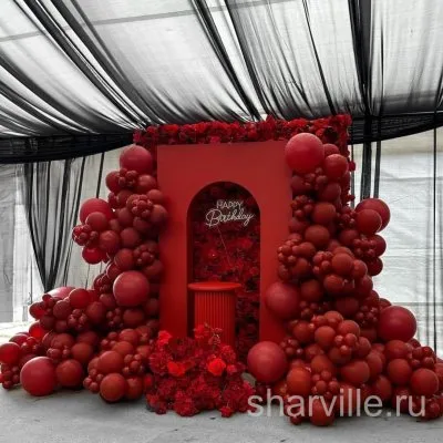 Фотозона с аркой из красных шаров, цветочным фоном и неоновой надписью Happy Birthday