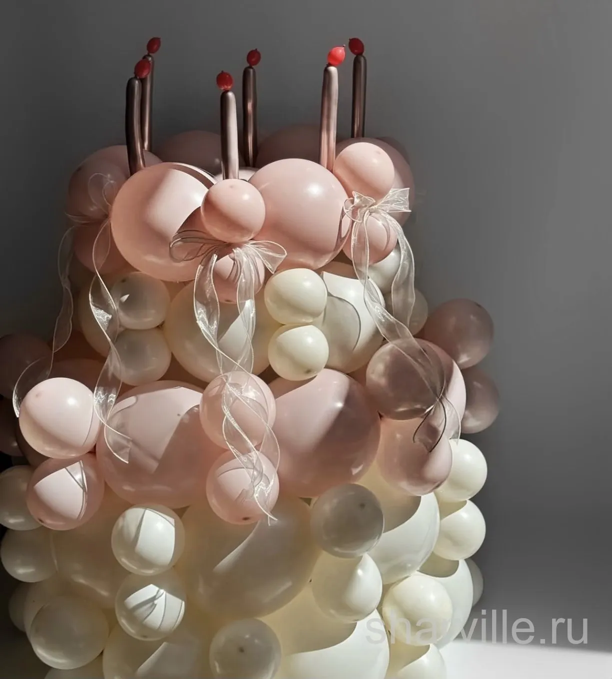 Плетёный торт из розовых и белых шаров с объёмными свечами и бантами