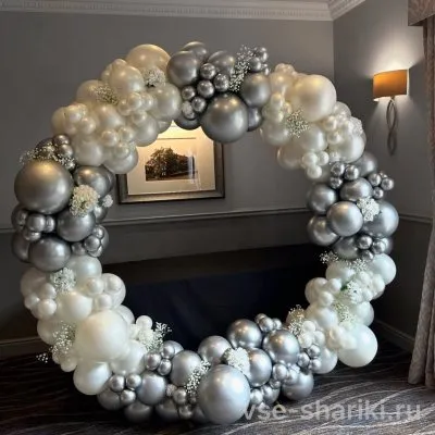 Фотозона-круг с серебристыми и белыми шарами и декоративными цветами